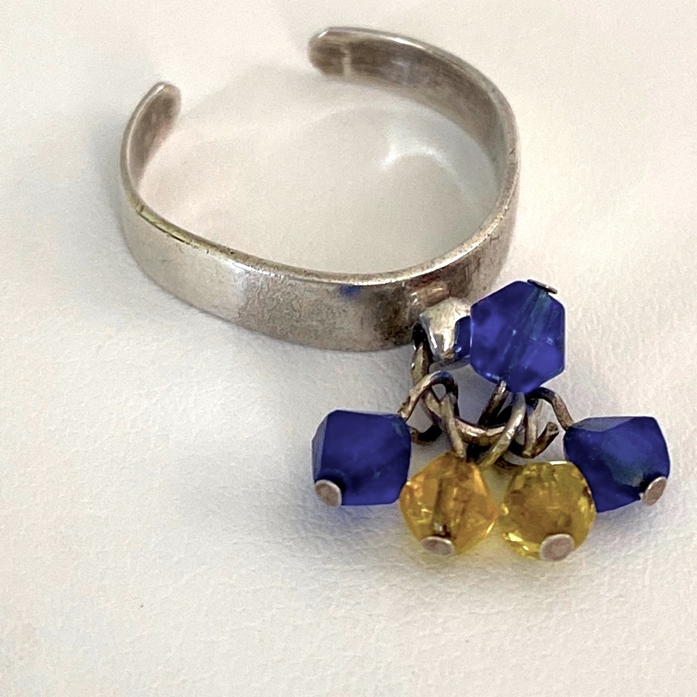 Dangling yellow and blue crystals on a silver toe ring